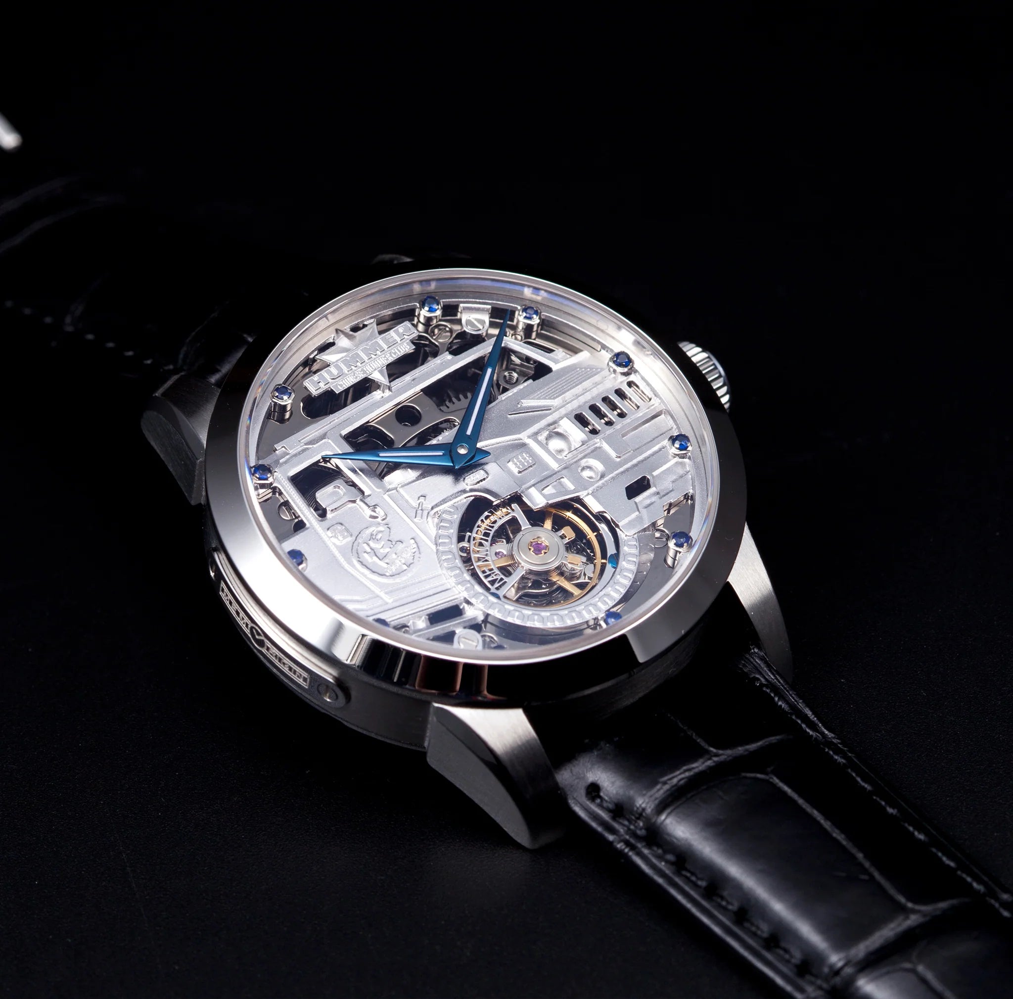 Luxury watch with transparent case and black leather strap on a dark background
