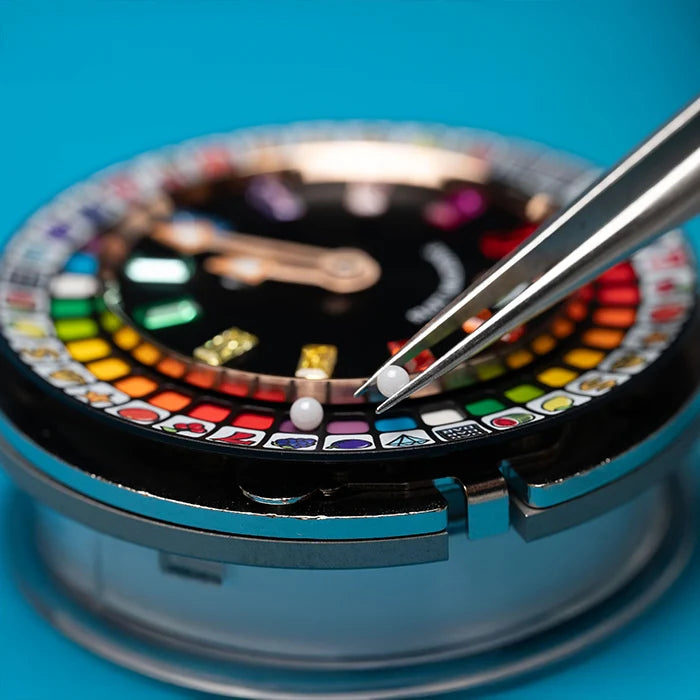 Close-up of a watch with a colorful face and tweezers on a blue background