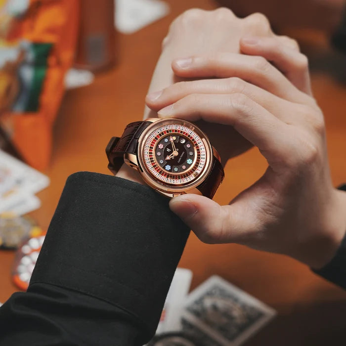 Person holding a rose gold watch with a detailed face on a blurred background