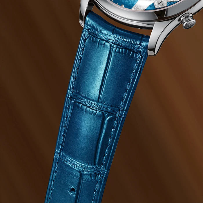 Close-up of a blue leather watch strap with silver watch case on a brown background