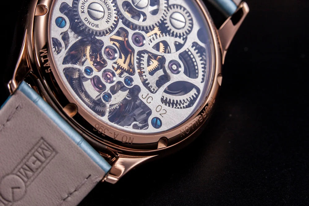 Close-up of a mechanical watch with visible brand name on a dark background