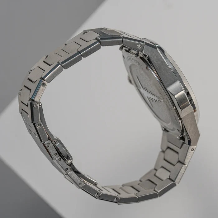Silver watch with a metallic band on a gray background