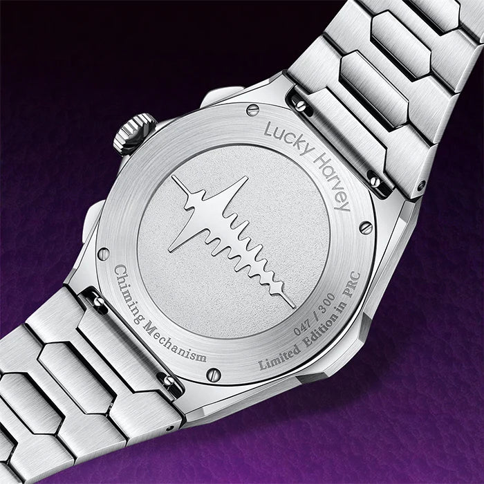 Close-up of the back of a stainless steel wristwatch with a matching metal link bracelet, featuring engraved text including 'Lucky Harvey' and 'Chiming Mechanism' on a dark purple background.
