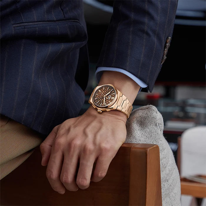 Person wearing a gold wristwatch on a blurred indoor background