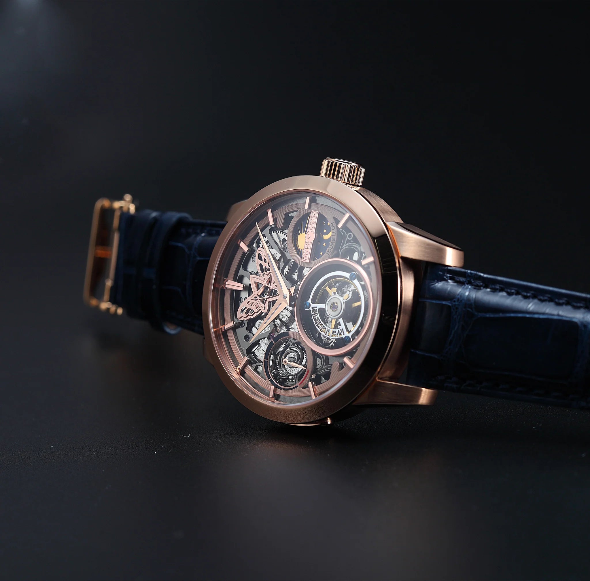 Luxury watch with a blue strap and rose gold case on a dark background