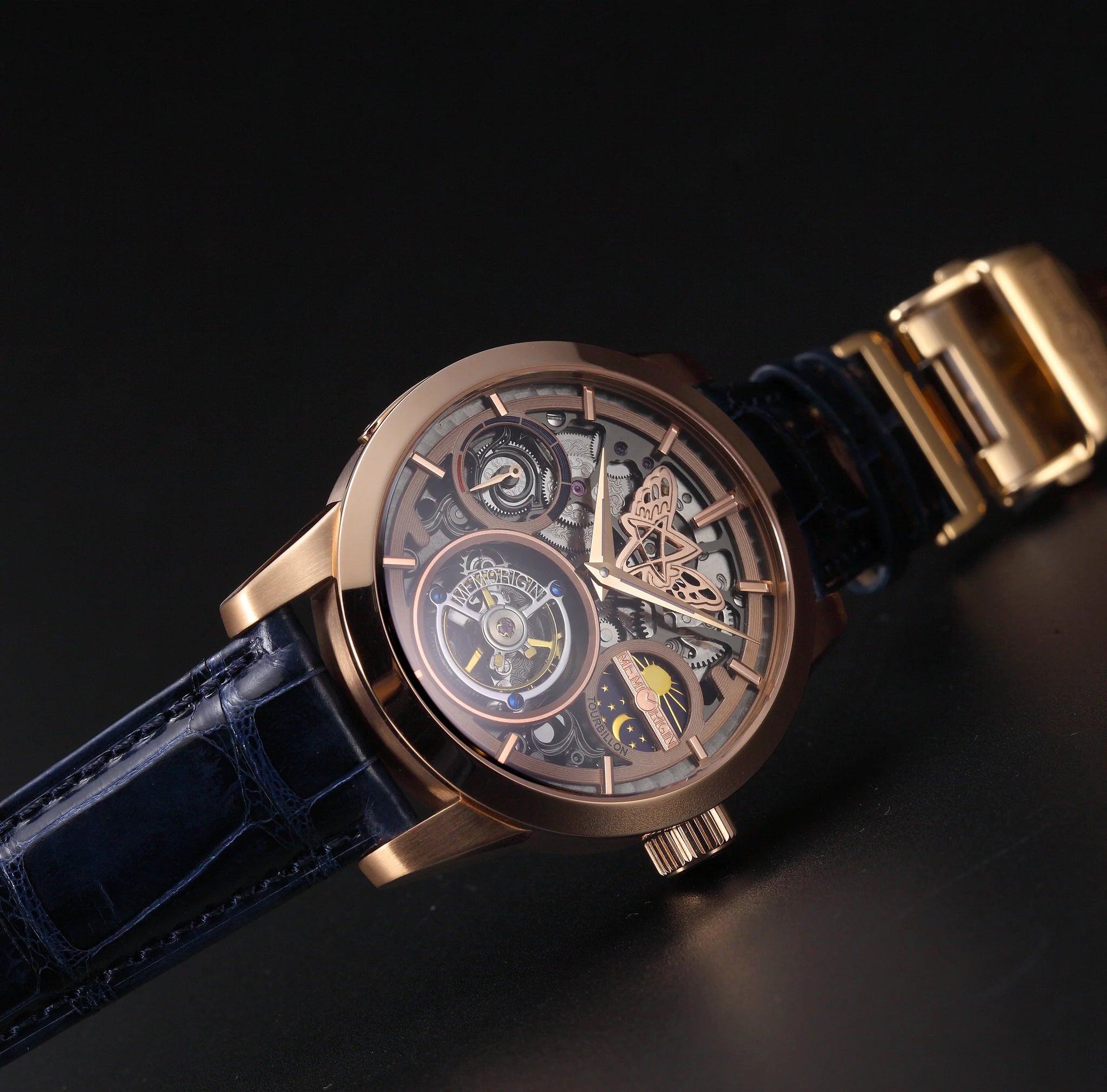 Luxury watch with gold case and blue strap on a dark background
