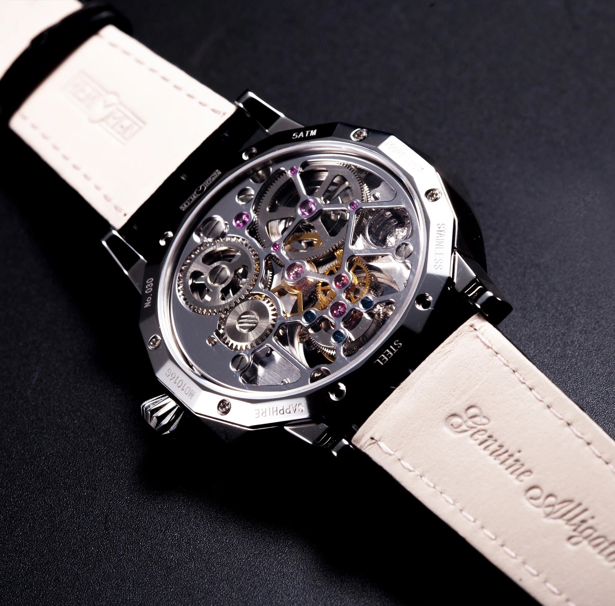 Close-up of a mechanical watch with a white strap on a dark background