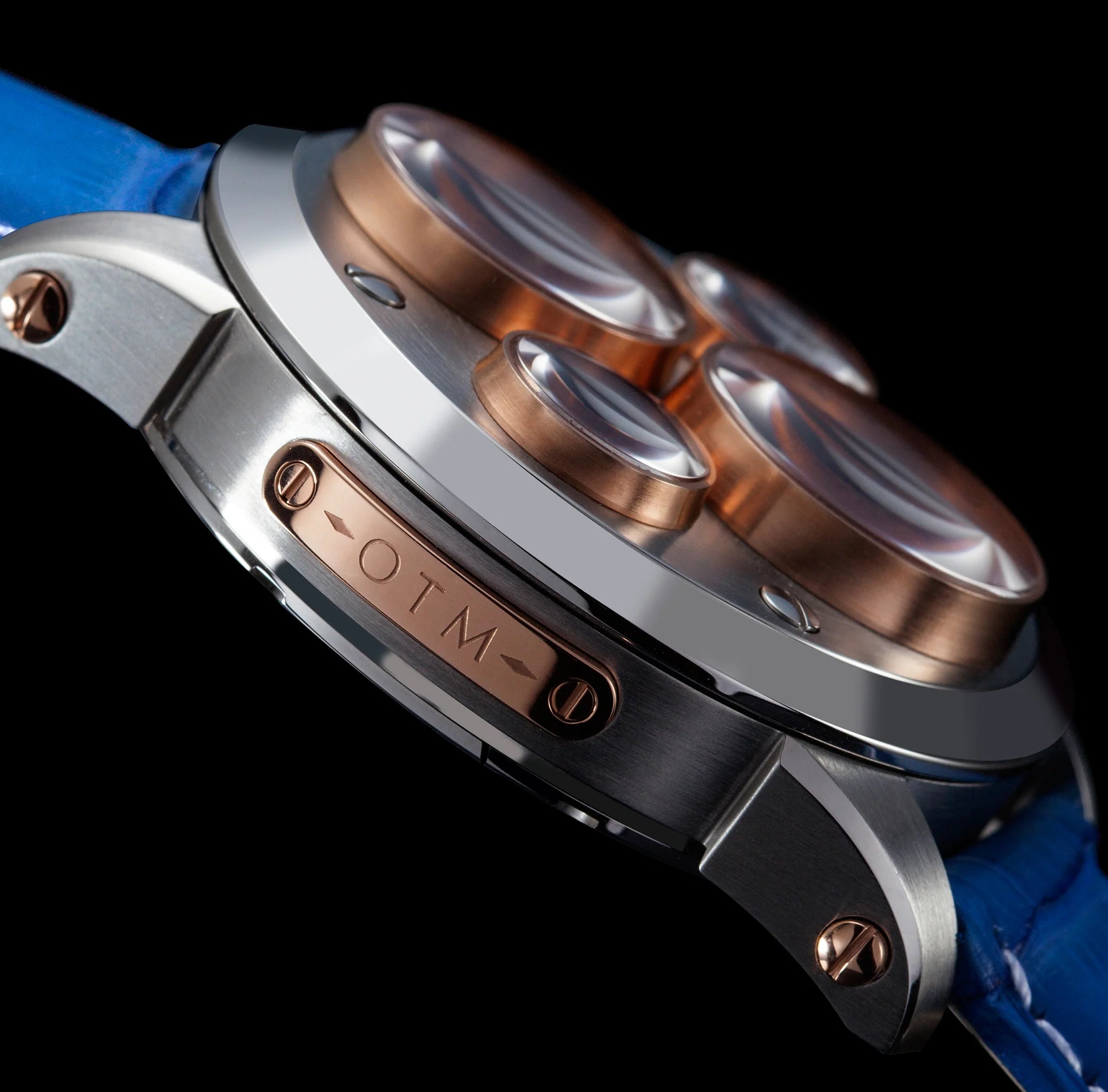 Close-up of a watch with metallic case and blue strap on a black background