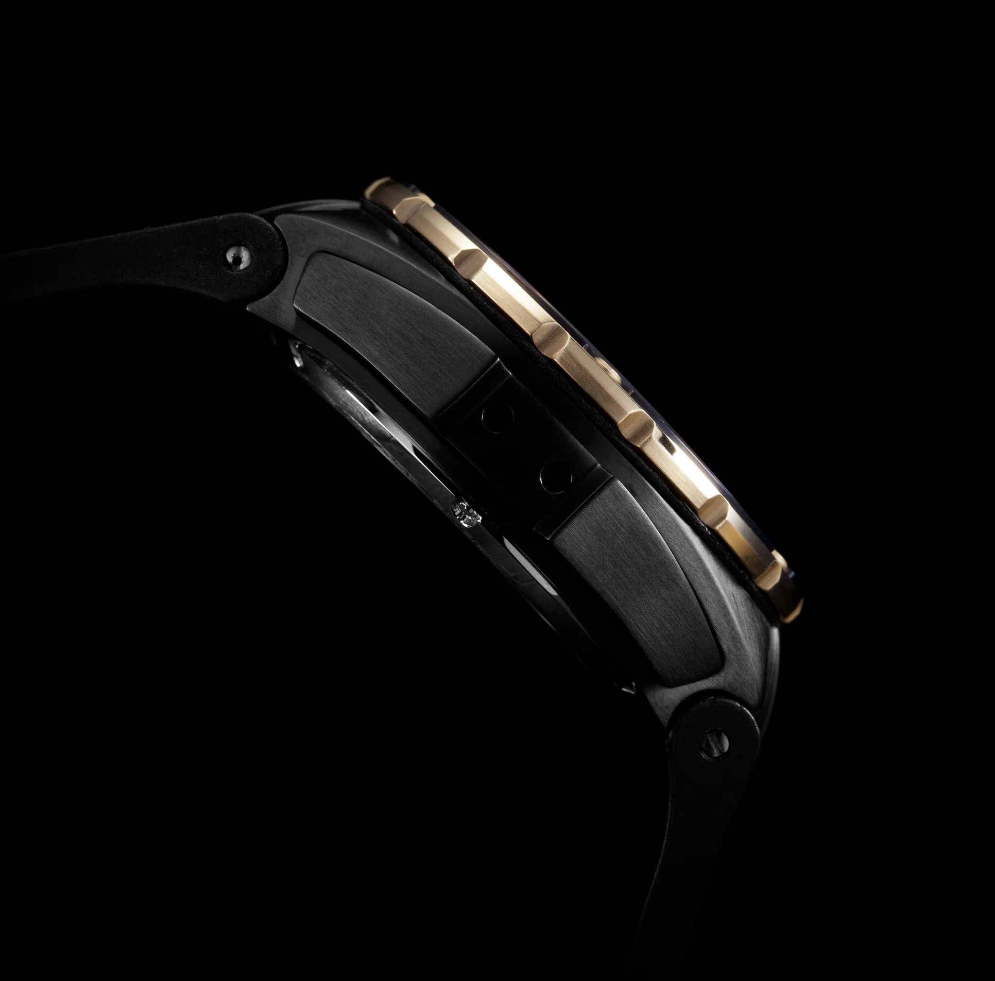 Close-up of a black and gold Tourbillon watch on a black background