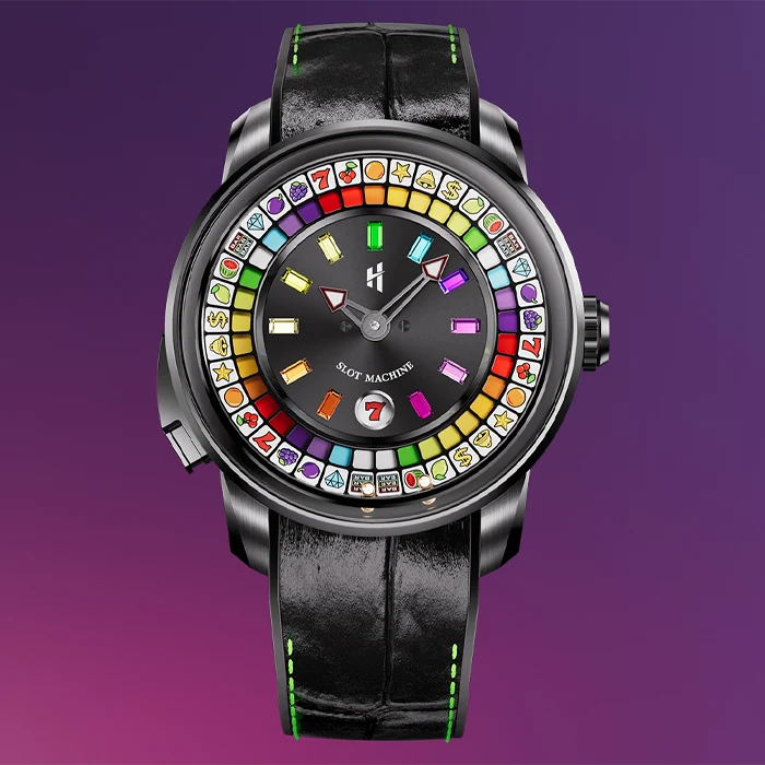 A luxury watch with a black leather strap and a round black dial featuring a colorful ring of game symbols, with the text 'SLOT MACHINE' on the dial, set against a purple gradient background.