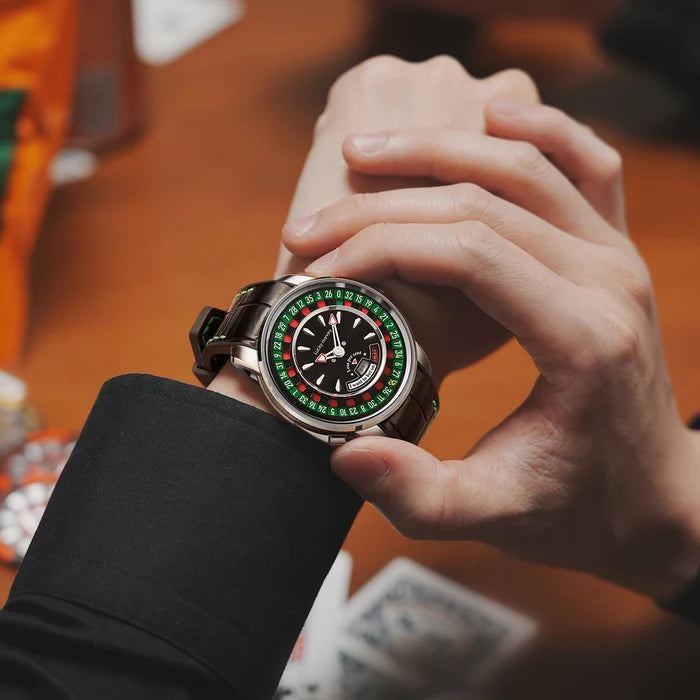 Close-up of a hand wearing a luxurious watch with a colorful face on a blurred background.