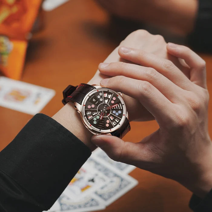 Close-up of a person's hand wearing a detailed wristwatch with playing cards in the background.