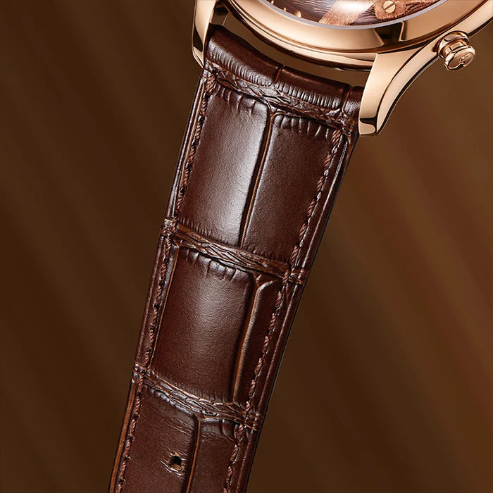Close-up of a luxury watch featuring a dark brown alligator leather strap and a rose gold case against a warm brown background.