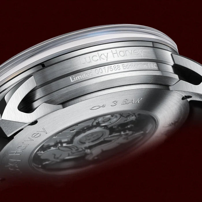 Close-up of a luxury watch case with 'Breguet' branding on a dark background