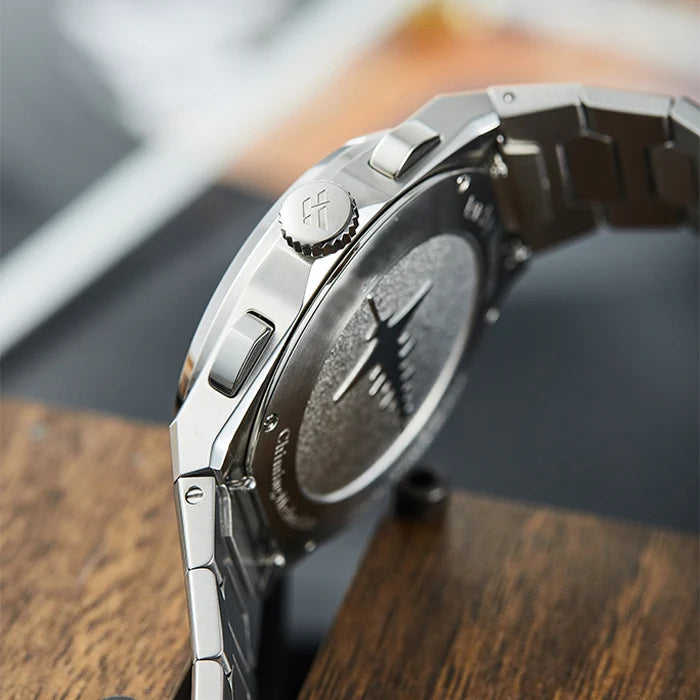Close-up of a silver watch on a wooden surface with blurred background
