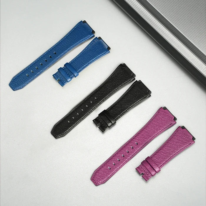 Set of blue, black, and pink watch straps on a light gray background