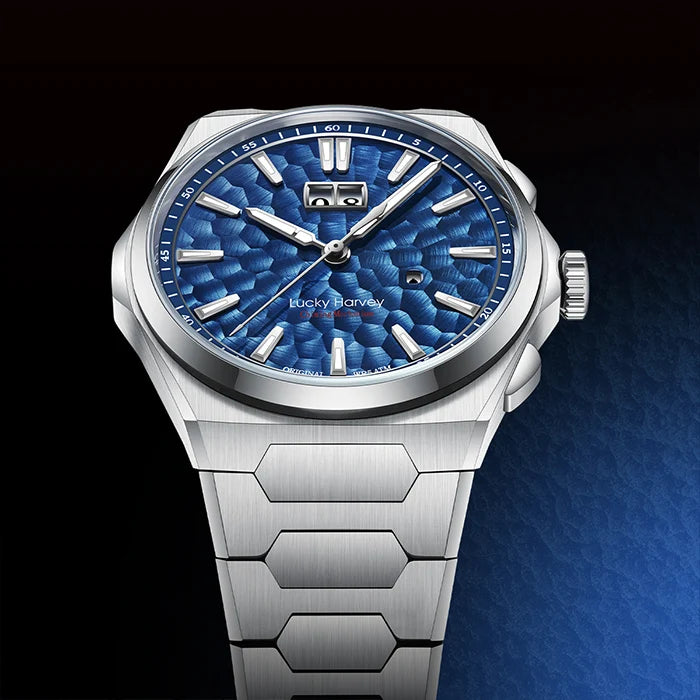 Silver watch with a blue textured face on a dark background