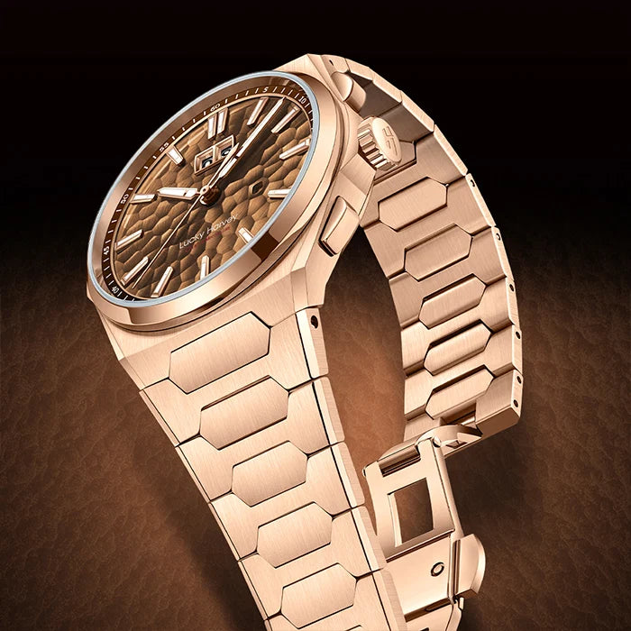 A luxury wristwatch with a rose gold-toned metal link bracelet and a textured rose gold dial, shown at an angle against a dark brown background.