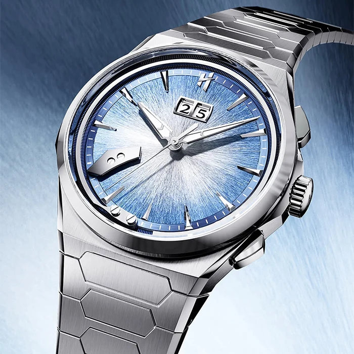 A close-up of a titanium steel wristwatch with a blue sunburst dial, silver case, and matching metal link bracelet against a blue gradient background.