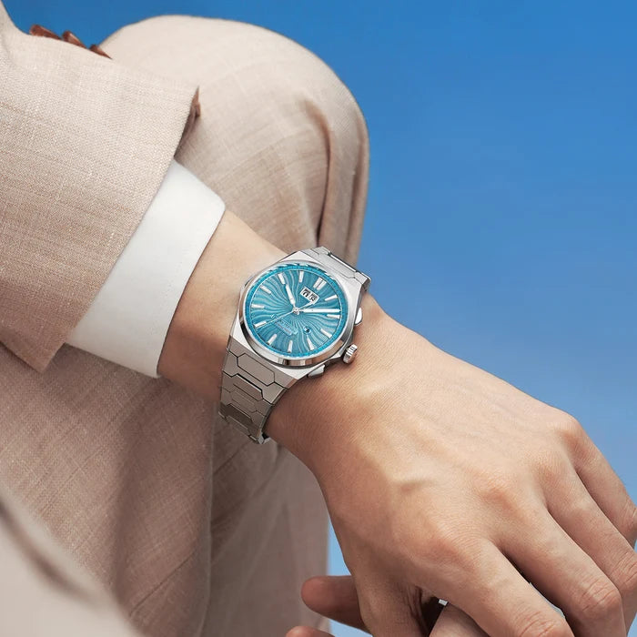 Wrist wearing a watch with a blue face against a blue background