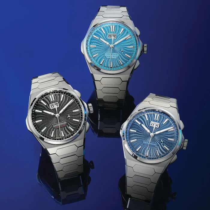 Three silver watches with blue and black faces on a dark blue background
