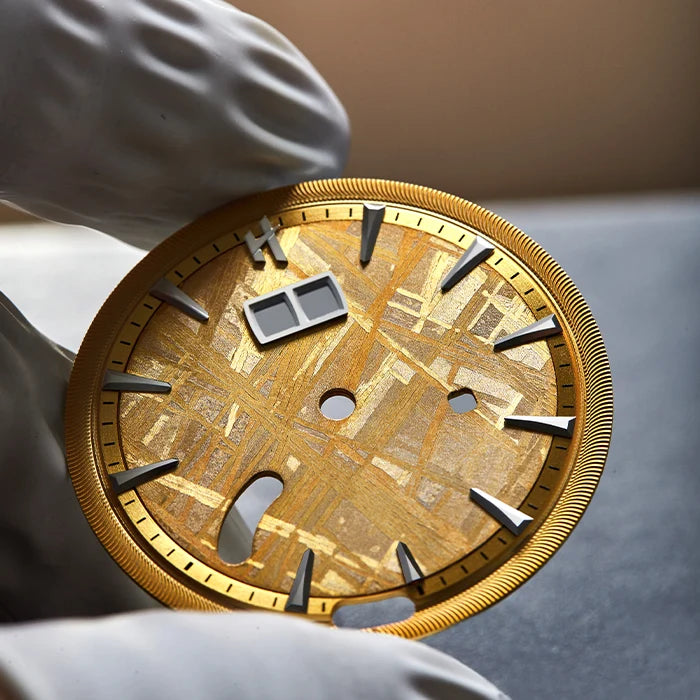 Gold circular object with Roman numeral design held by a classical statue hand