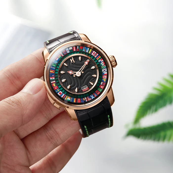 A close-up of a hand holding a luxury watch with a rose gold case, a black leather strap, and a colorful world map dial.