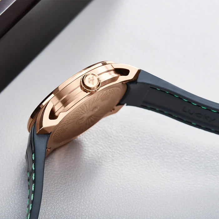 Close-up of a rose gold watch case with a black strap on a light gray background