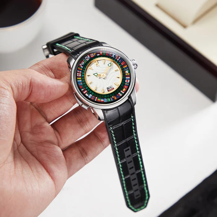 Hand holding a watch with a colorful face and black strap on a light background